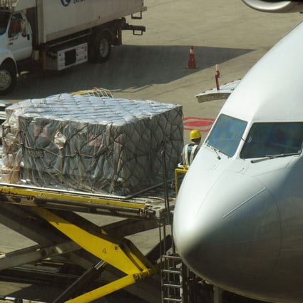 Workers unload goods onto a plane at Shanghai Pudong International Airport, where recent cases of coronavirus among workers have caused freight delays and diverted flights. Photo: AFP