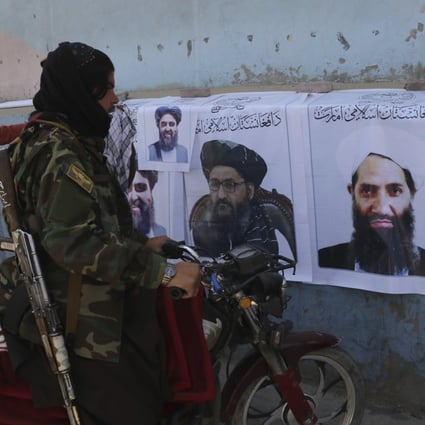 A Taliban fighter looks at Taliban flags and posters of leaders in Kabul. Photo: AP