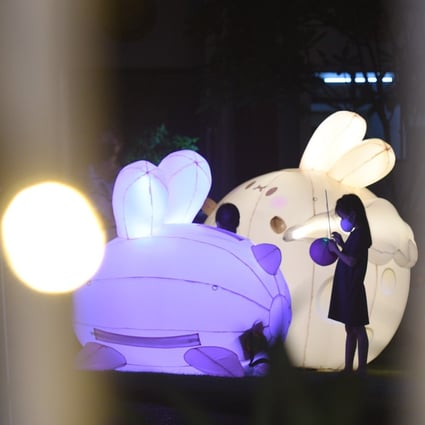 Children wearing face masks play around jade rabbit lantern installations in Singapore on Monday, the seventh consecutive day of more than 100 locally transmitted Covid-19 infections in the city state. Photo: Xinhua