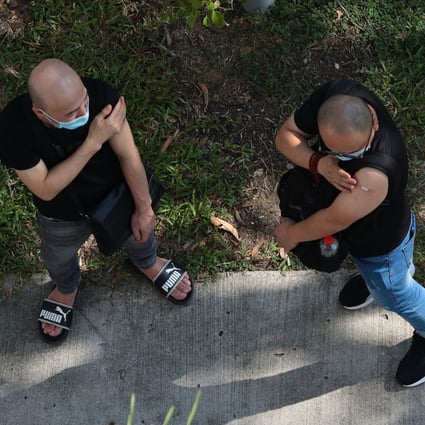 Two men wait outside a clinic after receiving the China-made Covid-19 Sinovac vaccine in Singapore. Photo: Getty Images