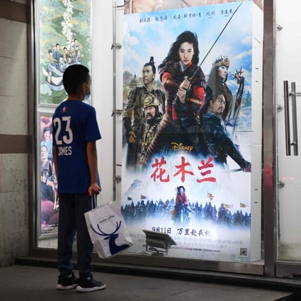 A boy looking at poster of the Disney movie “Mulan” outside a cinema on the day of its premiere in Beijing on September 11, 2020. Photo: AFP