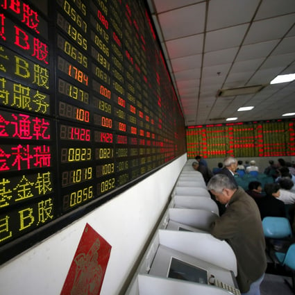 Investors look at computer screens showing stock information at a brokerage house in Shanghai. Photo: Reuters
