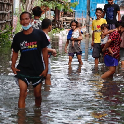 Villagers wade though floodwaters after the Philippines was hit by two major tropical storms in a week. Photo: EPA-EFE