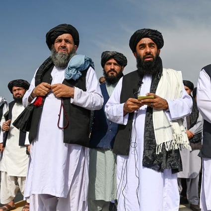 Taliban spokesman Zabihullah Mujahid (centre) speaks to reporters at the airport in Kabul on August 31, after the last US troops had pulled out. Photo: AFP