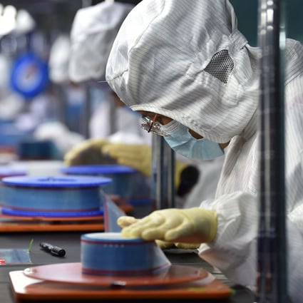 Factory workers produce adhesive tape for flexible printed circuits in China’s Jiangsu province. Photo: AFP