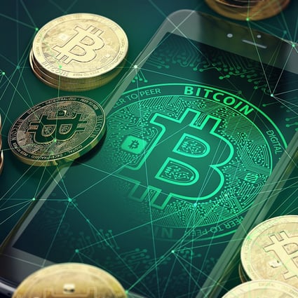 Smartphone with bitcoin symbol on-screen among piles of golden Bitcoins. Photo: Shutterstock