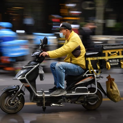 A delivery rider for Meituan, one of China's biggest food delivery firms, making a delivery after picking it up at a restaurant in Beijing on April 27. Photo: AFP