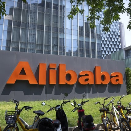 A woman walks past the offices of Alibaba in Beijing on August 10, 2021. Photo: AP