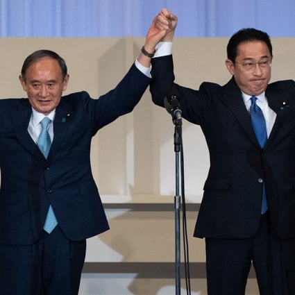 The LDP’s new leader Fumio Kishida (R) celebrates with outgoing PM Yoshihide Suga. Photo: AFP