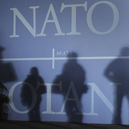 Attendees’ shadows are cast on a wall decorated with the Nato logo before the start of a summit in France in April 2009. Photo: AFP