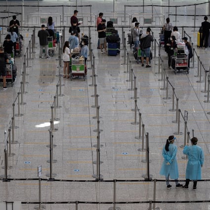 Travellers wait to be taken to government-designated quarantine hotels at Hong Kong International Airport. Photo: EPA-EFE