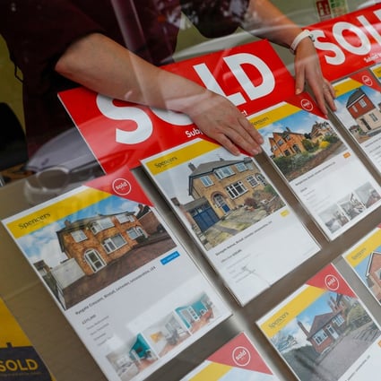 A property agent arranges a window display at Spencers in Birstall, UK in July 2021. Property prices are seen moderating in the coming months. Photo: Bloomberg