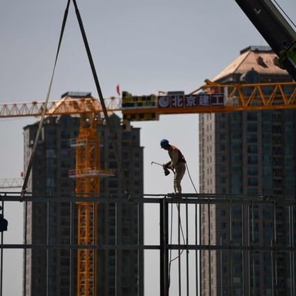 A worker prepares to weld a steel structure at a construction site in Beijing. Chinese property firms are scrambling to avoid outright default on their upcoming debt obligations. Photo: AFP