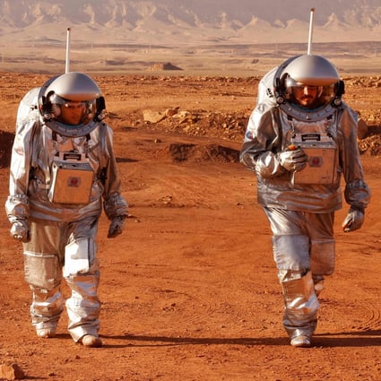 Two members from the team walk in spacesuits during a training mission. Photo: AFP