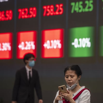 A woman stands in front of a screen showing stock exchange and economic data in Shanghai. Photo: EPA-EFE