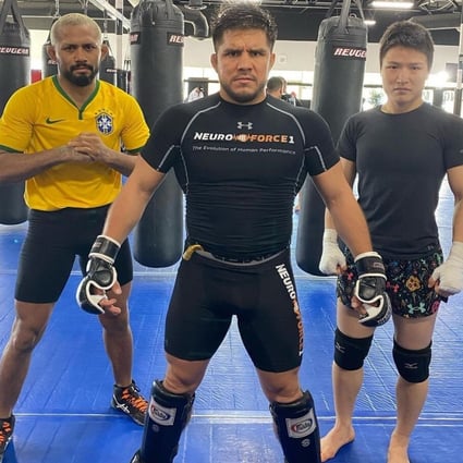 Henry Cejudo (centre) poses with Zhang Weili (right) and Deiveson Figueiredo at the Fight Ready gym in Scottsdale, Arizona.