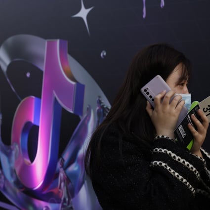 A woman speaks on her phone near a Douyin logo in Beijing on March 31, 2021. Photo: AP Photo