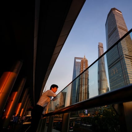 A man makes a phone call through the headset in the Lujiazui financial district in Pudong, Shanghai in July 2021. Photo: Reuters