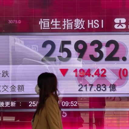 A woman walks past a bank's electronic board showing the Hang Seng Index on October 25. Photo: AP