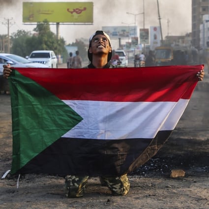A Sudanese protester holds the national flag during a demonstration in the capital Khartoum on Tuesday. Photo: EPA-EFE