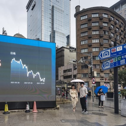 People stand next to a screen showing stock exchange and economic data in Shanghai. Photo: EPA-EFE