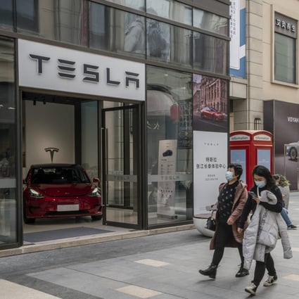 Shoppers walk past a Tesla showroom in Shanghai. Photo: Bloomberg