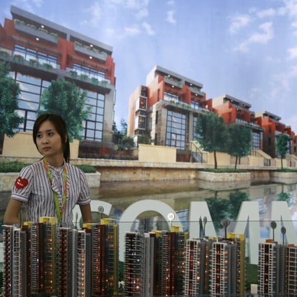 A sales agent and the model of a property development at the 5th China (Shenzhen) Real Estate Fair in Shenzhen on May 4, 2010. Photo: Reuters.
