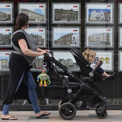 A woman looks at adverts in an estate agent window in south-west London. Photo: EPA-EFE
