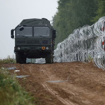 An army vehicle patrols next to a fence built by Polish soldiers on the border with Belarus. Photo: Reuters