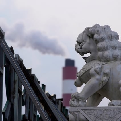 A chimney of a coal-fired power plant stands behind a lion statue in Shanghai on October 21, 2021. Photo: Reuters