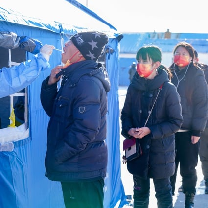 A medical worker takes a sample as people queue to be tested in the snow in Heilongjiang. Photo: Xinhua