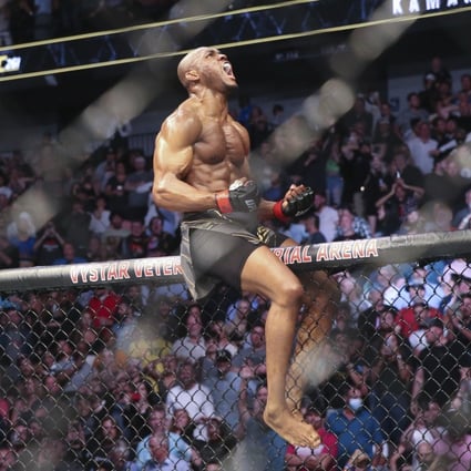 Kamaru Usman celebrates his win atop the octagon fence after a UFC 261 mixed martial arts bout against Jorge Masvidal in April, 2021. Photo: AP