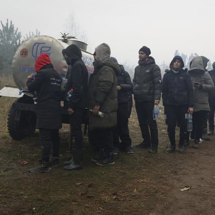 Migrants from the Middle East and elsewhere stand in line at a drinking water tank at the Belarus-Poland border near Grodno, Belarus, on November 11. Photo: AP
