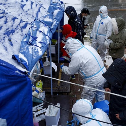 People line up for nucleic acid testing in the snow at a testing site in Jinpu new area in Dalian. Photo: Reuters