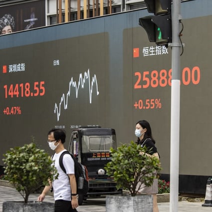 Pedestrians walk past a public screen displaying the Shenzhen Stock Exchange and the Hang Seng Index in Shanghai on August 18, 2021. Photo: Bloomberg