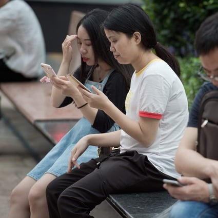 People use smartphones in Shenzhen, China. A new regulation proposed by the Cyberspace Administration of China would punish individuals and organisations for providing tools and services for others to access censored foreign websites. Photo: AFP Photo
