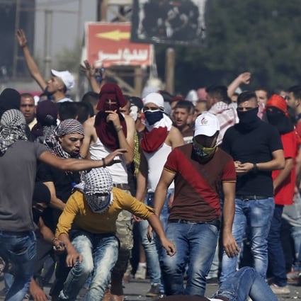 An injured Palestinian demonstrator is helped during clashes at the Hawara checkpoint near of the West Bank city of Nablus. Photo: AP