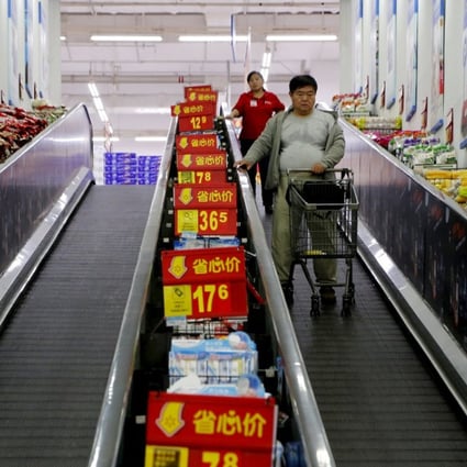 Shoppers ride on a travelator at a supermarket in Beijing, Photo: Reuters