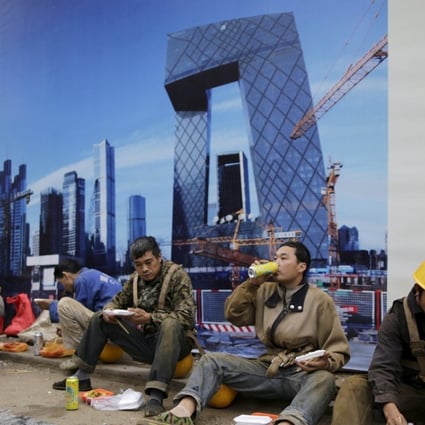 Construction workers have lunch outside a building site in Beijing, . Photo: Reuters