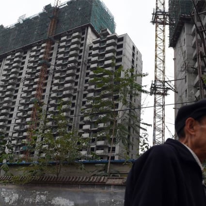 A man walks past a construction site for apartment buildings in Beijing. Photo: AFP