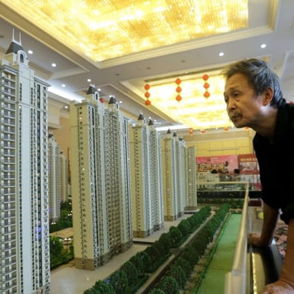 A visitor looks at a model of a new apartment complex at a showroom of Evergrande Real Estate Group in Wuhan, Hubei province, China. Photo: Reuters