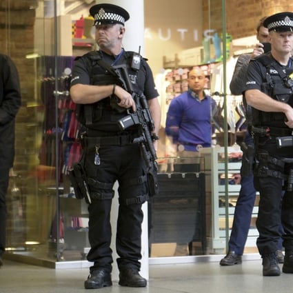 Armed police at the Eurostar terminal in London observe a minute of silence in honour of the victims of the Paris attacks. Security has also been stepped up outside the French embassy. Photo: AP