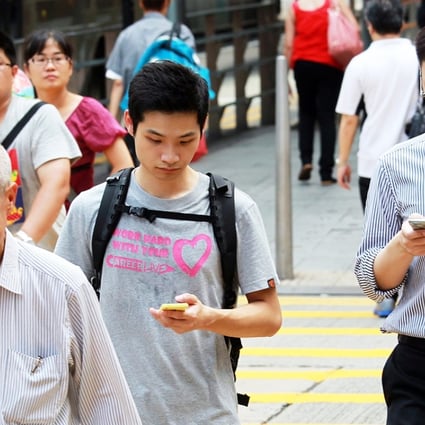 People using mobile devices on a street in Hong Kong. Picture: May Tse