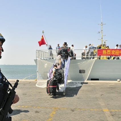 A navy soldier of People's Liberation Army (PLA) stands guard as Chinese citizens board the naval ship "Linyi" at a port in Aden. Photo: Reuters