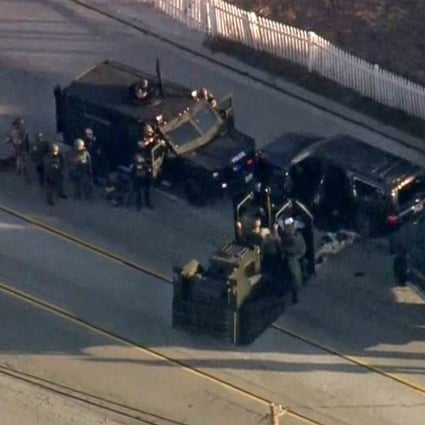 A still image from video courtesy of CBS News shows police in San Bernardino, California surrounding an SUV during an apparent shootout with suspects believed responsible for a mass shooting that left at least 14 people dead. Photo: AFP