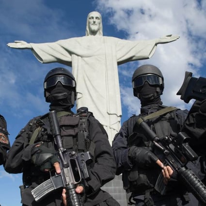 Members of the Elite Unit of the Special Police Operations Battalion (BOPE) posing between manoeuvres by the Christ the Reedemer statue in Rio de Janeiro, Brazil. Photo: AFP