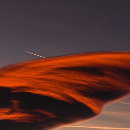 This photo shows a lenticular cloud forming as white streaks from airplanes mark the blue sky, in a rare atmospheric phenomena. Lenticular clouds have been regularly confused for UFOs throughout history due to the their smooth, round or oval lens-shaped structure. Photo: AFP