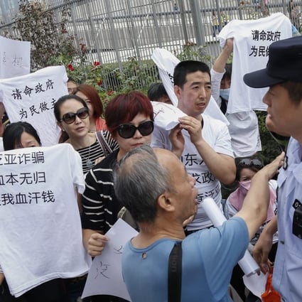 Protesters argue with a Chinese policeman (right) as they stage a demonstration in Beijing in September against Fanya Metal Exchange. File photo EPA