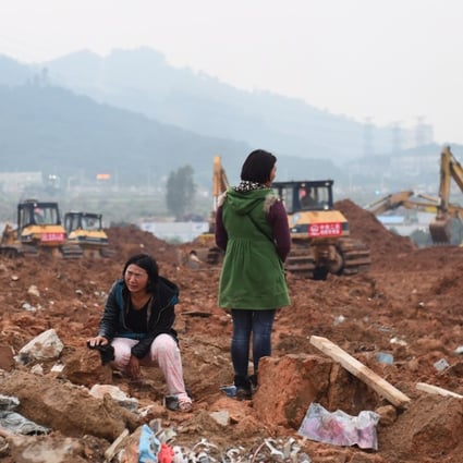 A woman looks for her missing sister and her sister's child at the site of landslide at an industrial park in Shenzhen on December 21. Photo: Xinhua