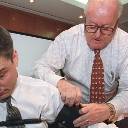 A former Federal Bureau of Investigation (FBI) agent (right) demonstrates a polygraph test on a volunteer, with sensors attached to his fingers, arm and chest. Photo: Garrige Ho